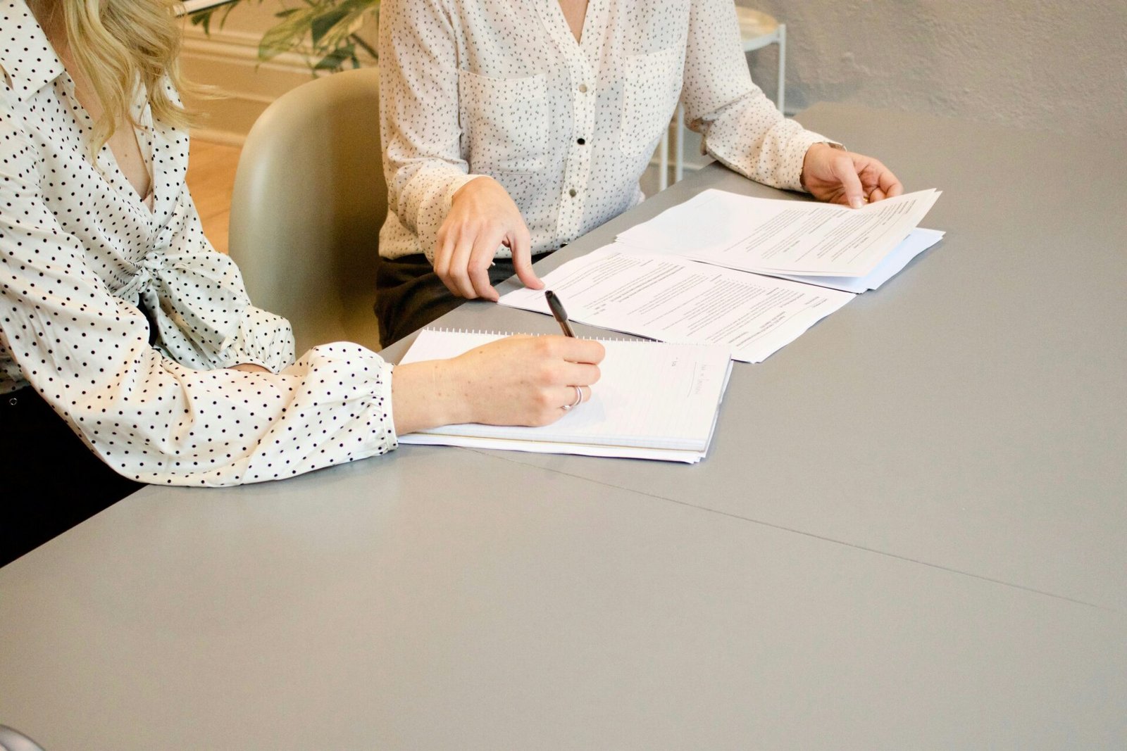 Négocier le meilleur taux d'intérêt. Sur la photo, nous voyons deux mains signant des documents de prêt immobilier.