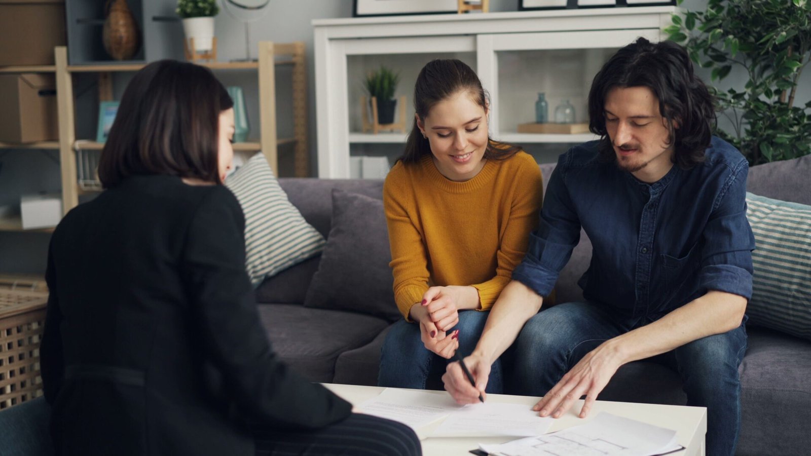 Couple en rendez-vous avec un conseiller pour préparer un dossier de prêt immobilier avant un achat immobilier.