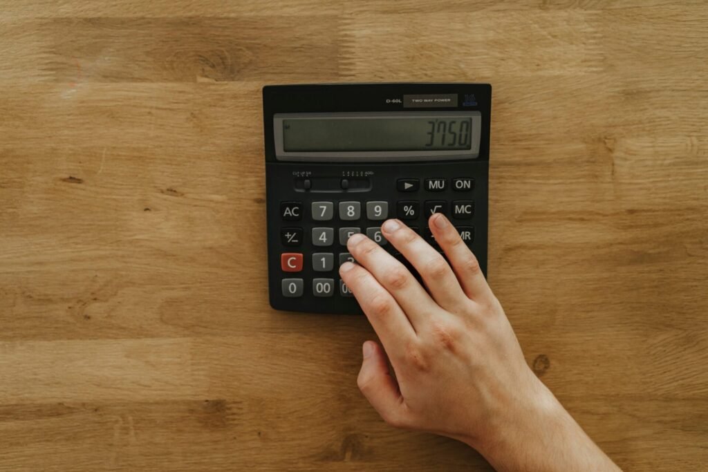 Main utilisant une calculatrice avec touche pourcentage pour illustrer le calcul du TAEG d’un crédit immobilier.
