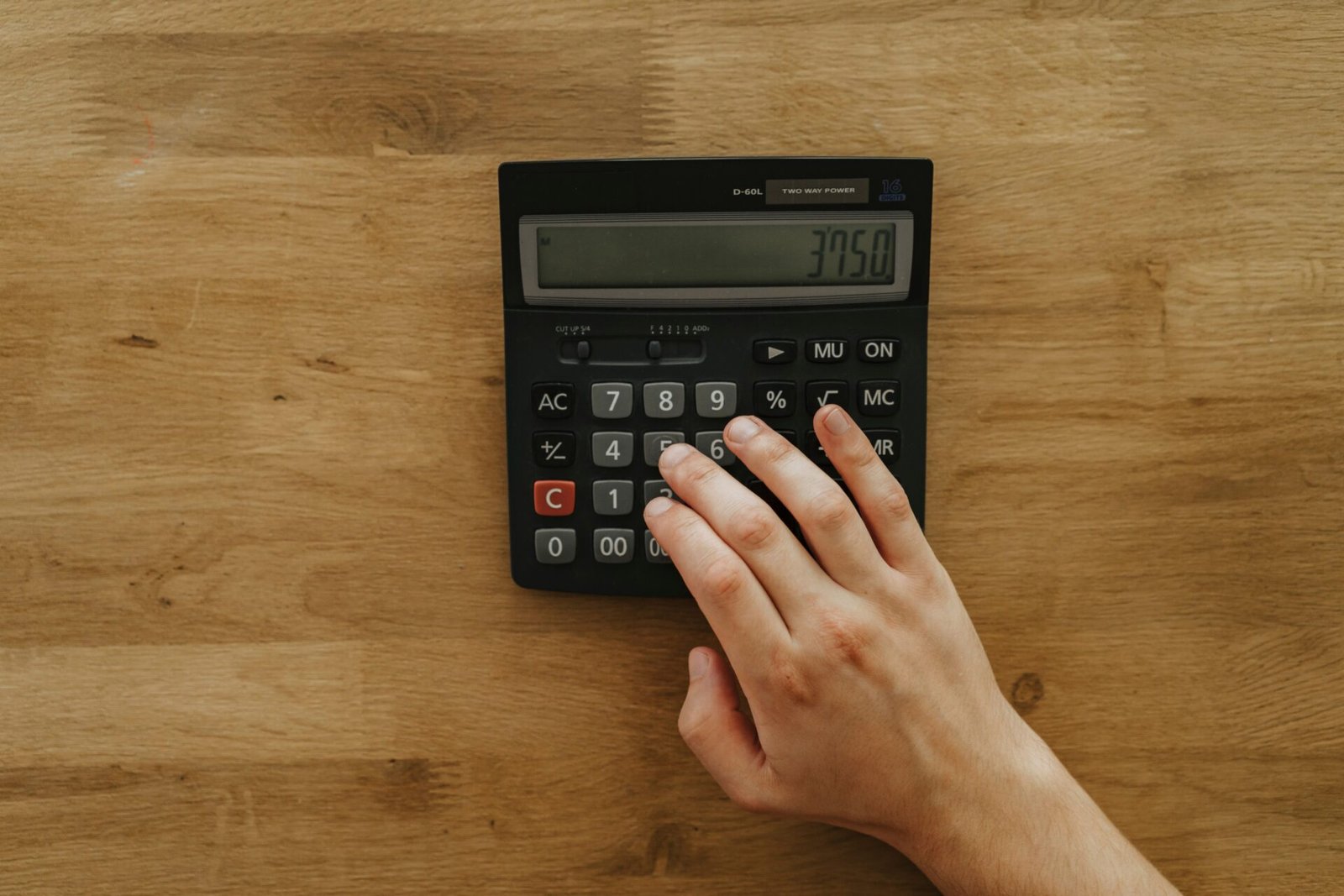 Main utilisant une calculatrice avec touche pourcentage pour illustrer le calcul du TAEG d’un crédit immobilier.